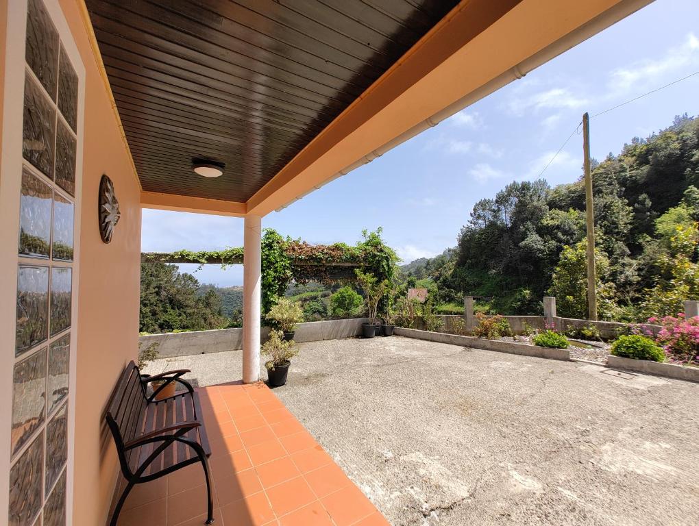 a patio with a bench and a view of the mountains at Casa Rosa - Vereda da Ilha in Santana