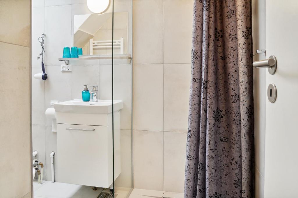 a bathroom with a shower curtain and a sink at NICE TOPFLOOR STUDIO APARTMENT in Copenhagen