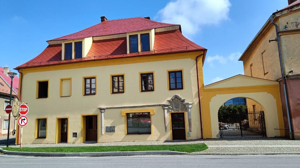 duży żółty budynek z czerwonym dachem w obiekcie Apartmány Javorník w Javorníku