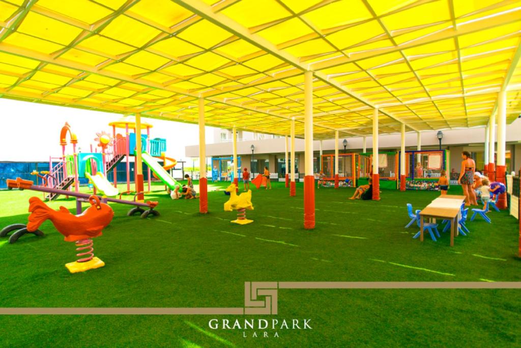 a play area with a playground with a yellow roof at Grand Park Lara Hotel in Lara