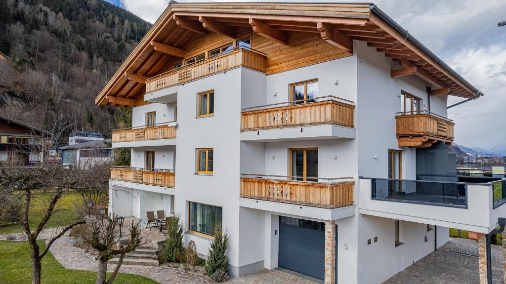 a house with a wooden roof at Panorama Apartments - Steinbock Lodges in Zell am See