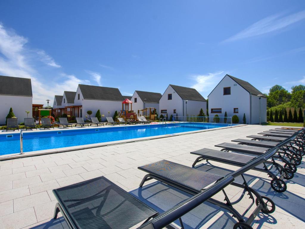 una fila de tumbonas junto a una piscina en Luxury homes with the pools for 8 persons, en Rogowo