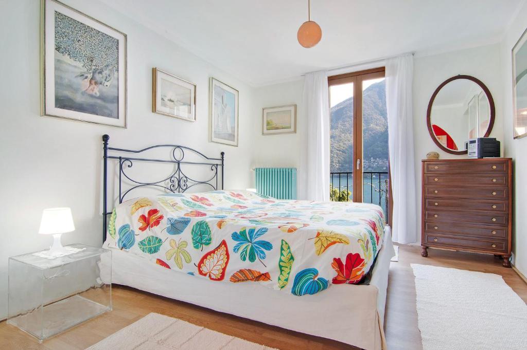sypialnia z łóżkiem, komodą i oknem w obiekcie Casa Armando w mieście Laglio