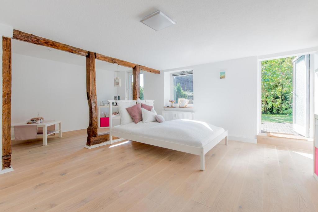 uma sala de estar branca com um sofá branco e janelas em Private Room with own bathroom em Burgwedel