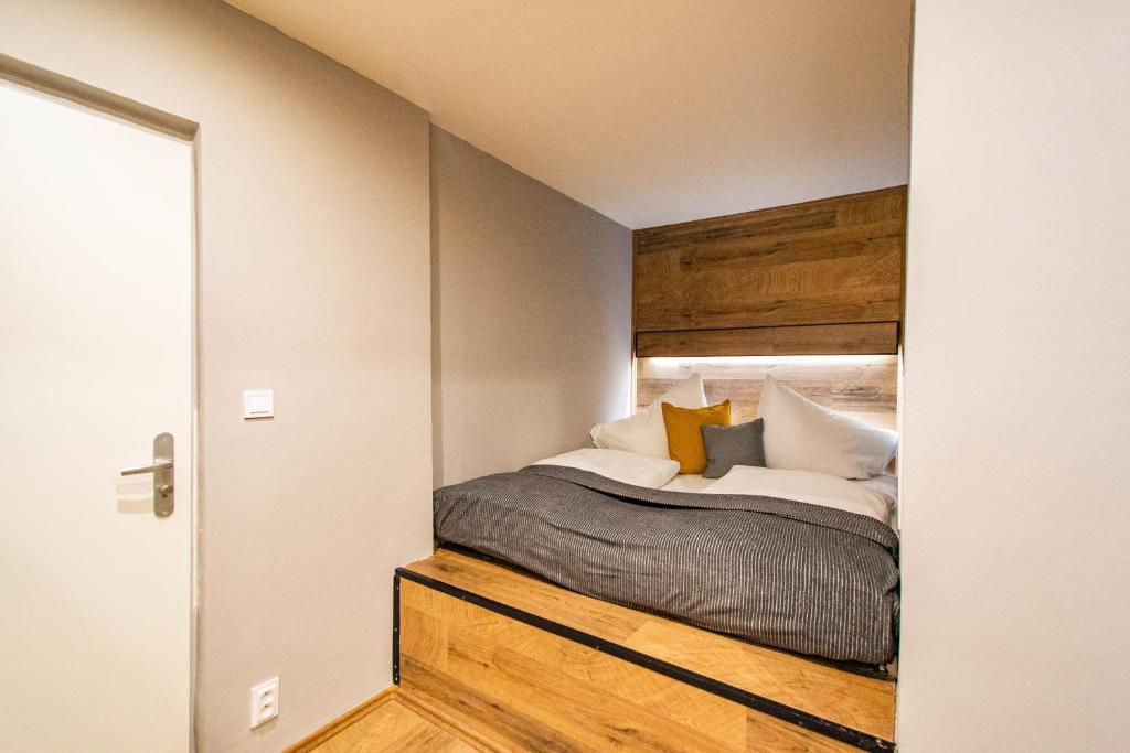 een slaapkamer met een bed met een houten hoofdeinde bij Cozy studio in the main city center in Praag