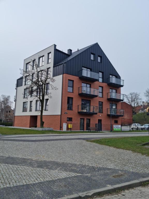 um edifício de apartamentos com um telhado preto em Apartament Nad Wisłą em Tczew