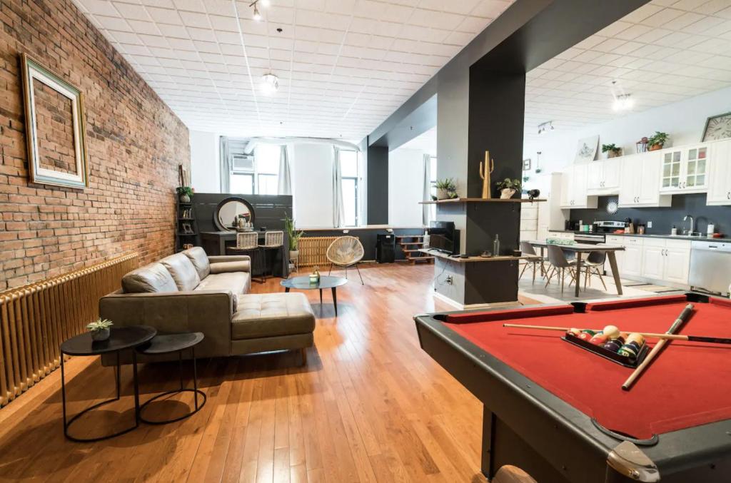 a living room with a couch and a table with a pool table at STUNNING Old Port lofts in Montréal