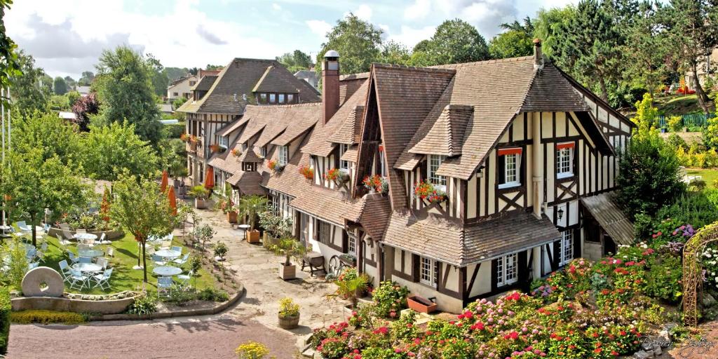 a row of houses with flowers and a garden at Hostellerie et SPA de la Vieille Ferme in Criel-sur-Mer