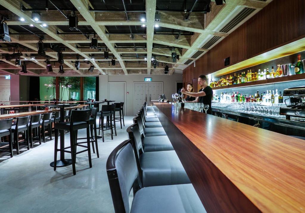 a bar with a man standing at the counter at Elma Hotel and Art Complex in Zikhron Ya'akov