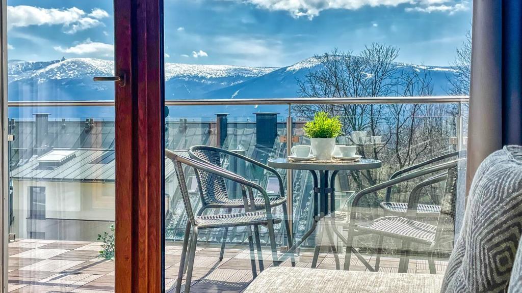 uma vista a partir de uma varanda com uma mesa e cadeiras em Apartamenty ROYAL APARTS VIP Widok 800 - z panoramą gór em Szklarska Poręba