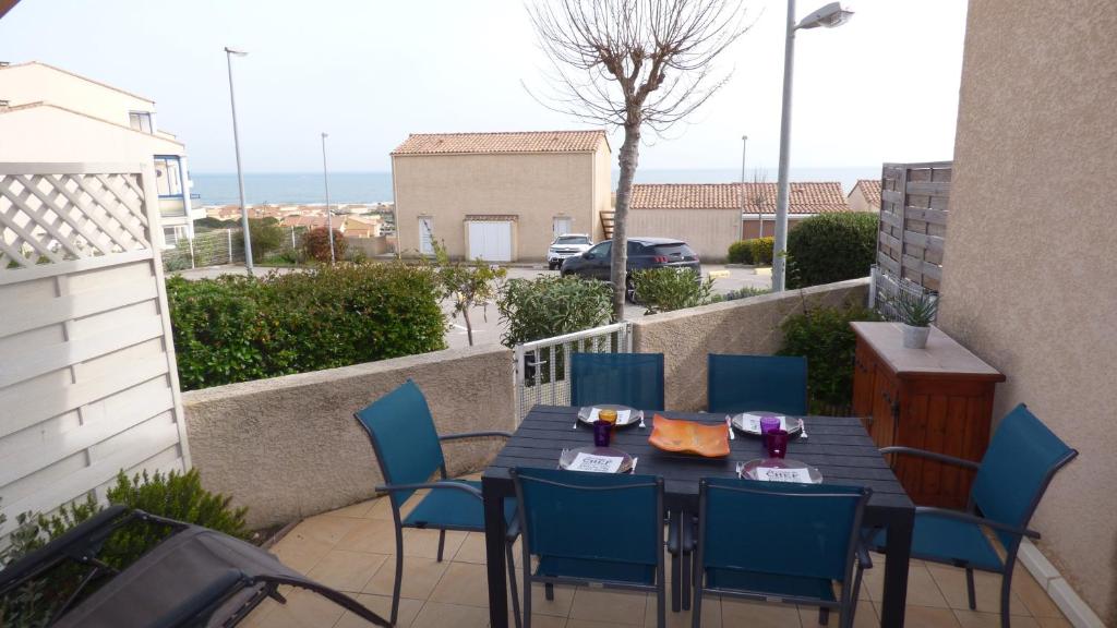 une table et des chaises sur un balcon avec vue sur l'océan dans l'établissement Pavillon T2 Mezzanine, piscine, Mer Indigo, St Pierre la Mer, à Saint Pierre La Mer