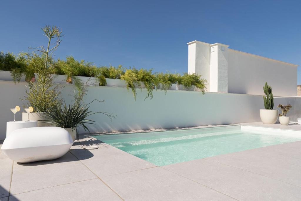 a swimming pool in a backyard with a white fence at Mylu Suites by Puerta Catedral in Seville
