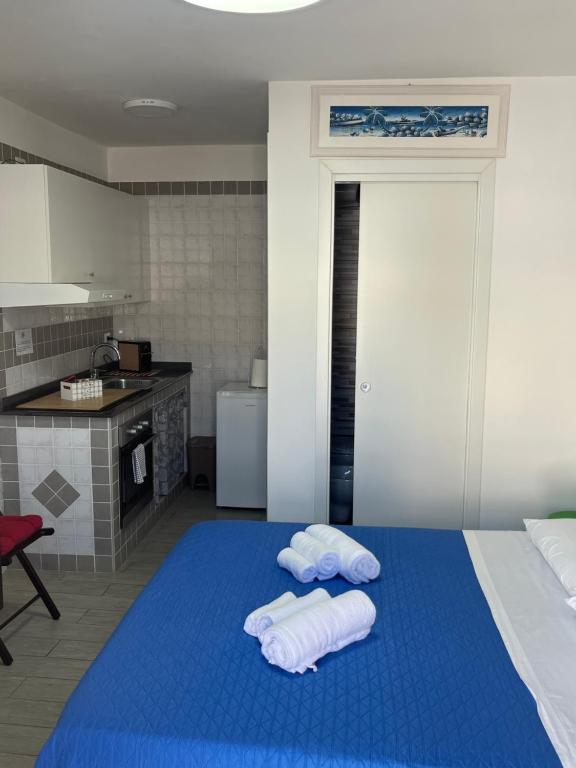 a bedroom with a blue bed with towels on it at Truly Apulia in Bari