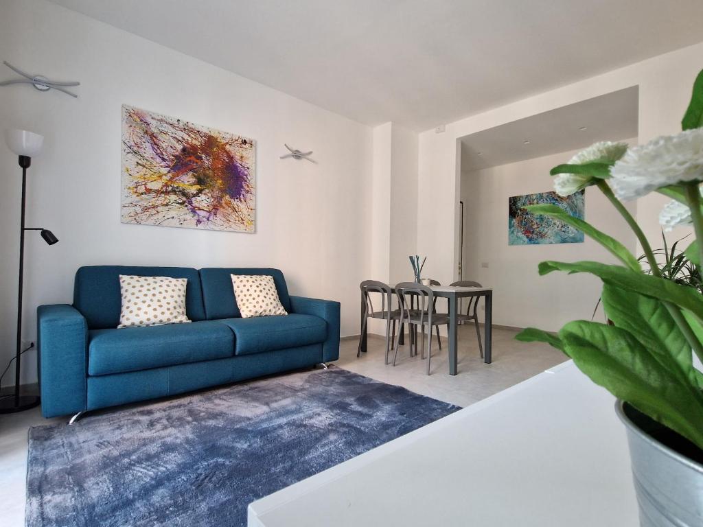 uma sala de estar com um sofá azul e uma mesa em Quick Flat - Milan Central em Milão
