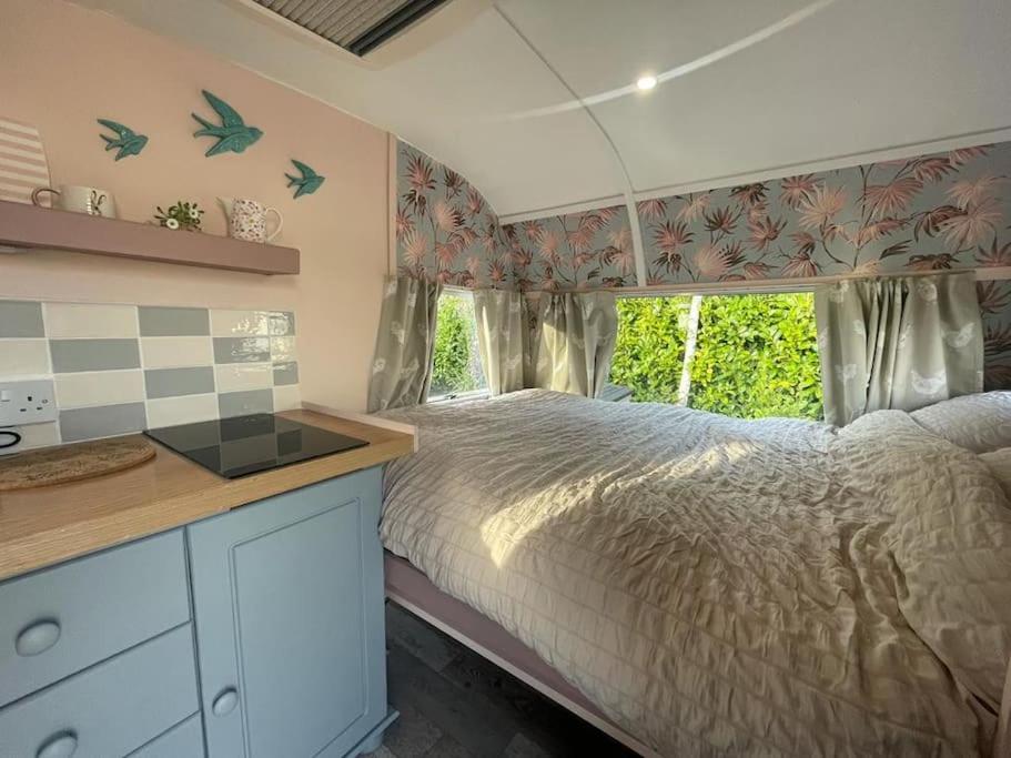 Wigton的住宿－Molly The Vintage Caravan.，一间卧室设有一张大床和一个窗户。
