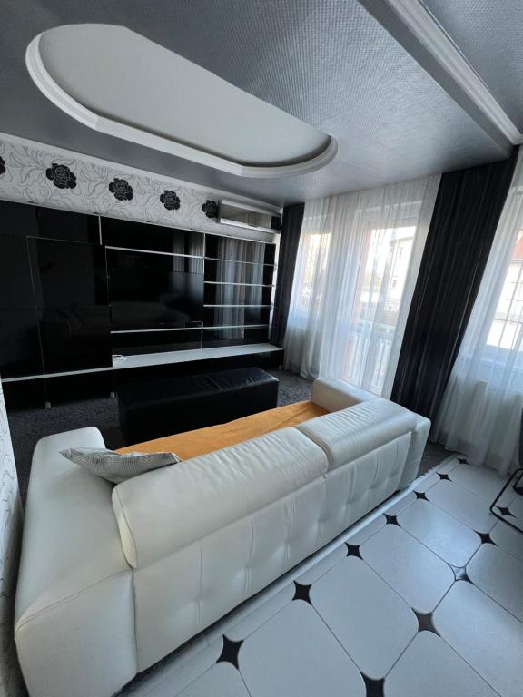 Prémium Apartman Nyíregyháza في نيرغهازا: غرفة معيشة مع أريكة بيضاء وطاولة