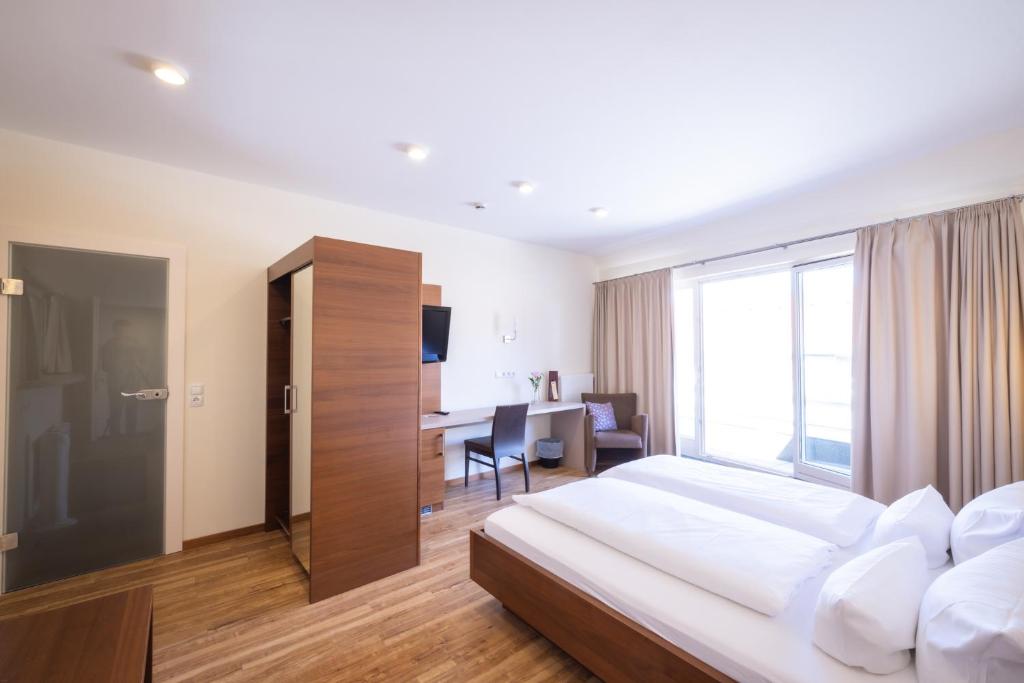 a bedroom with a bed and a desk in a room at Altstadthof Freinsheim in Freinsheim