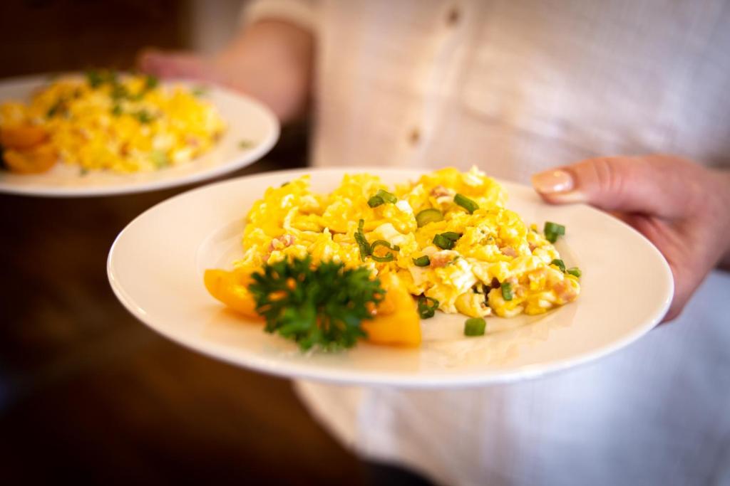 a person holding two plates of food on a plate at Altstadthof Freinsheim in Freinsheim