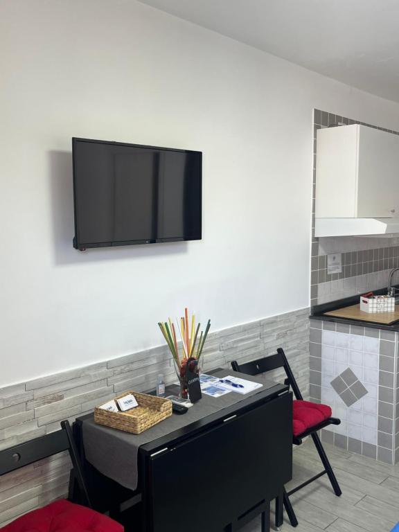a room with a table with chairs and a tv on the wall at Truly Apulia in Bari