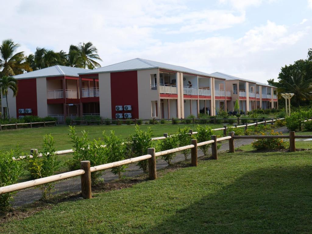 a row of buildings in a park with a fence at Village Kawann - Toumalacai 246 in Grand-Bourg