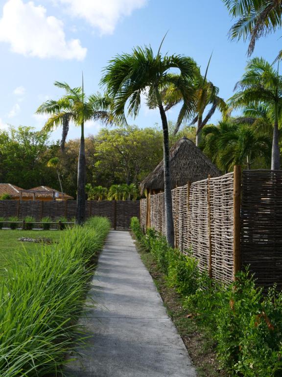 a pathway with palm trees and a fence at Village Kawann - Toumalacai 246 in Grand-Bourg