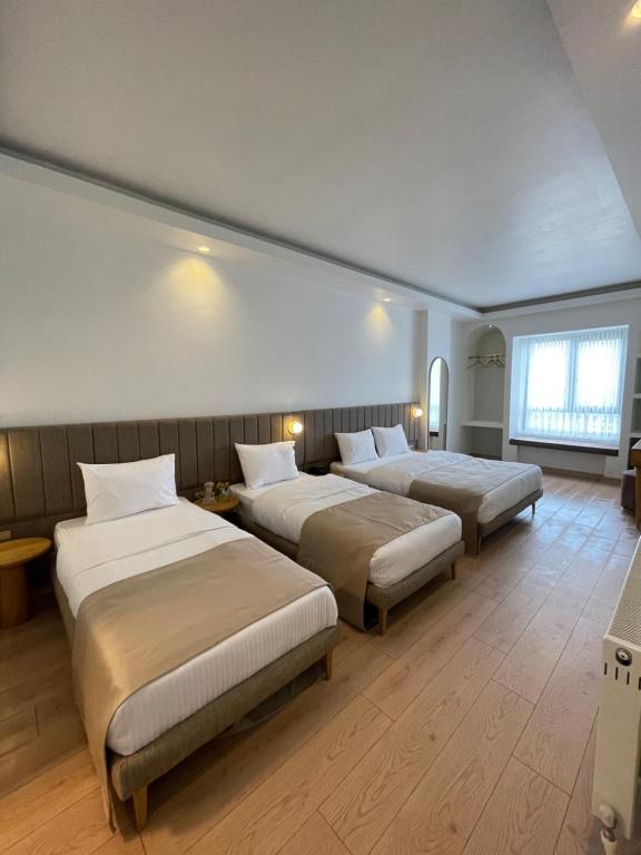 Habitación de hotel con 3 camas y ventana en Meshk Airport Hotel en Arnavutköy