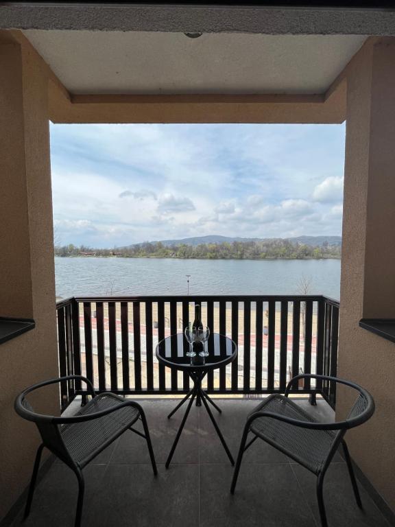 balcone con tavolo, sedie e vista sull'acqua di Apartman S2 a Ostrovo