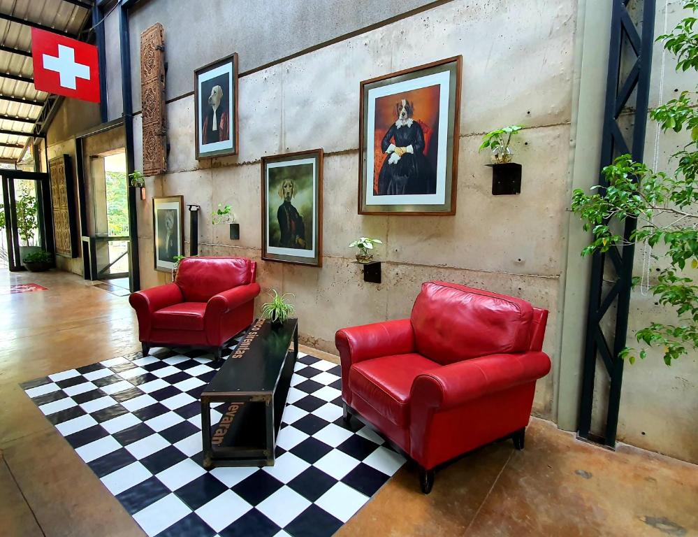 a living room with two red chairs and a checkered floor at Alfonsina Hotel Boutique in Santa Cruz de la Sierra