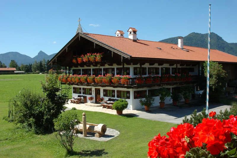 ein großes Gebäude mit Blumen davor in der Unterkunft Gästehaus Webermohof in Rottach-Egern