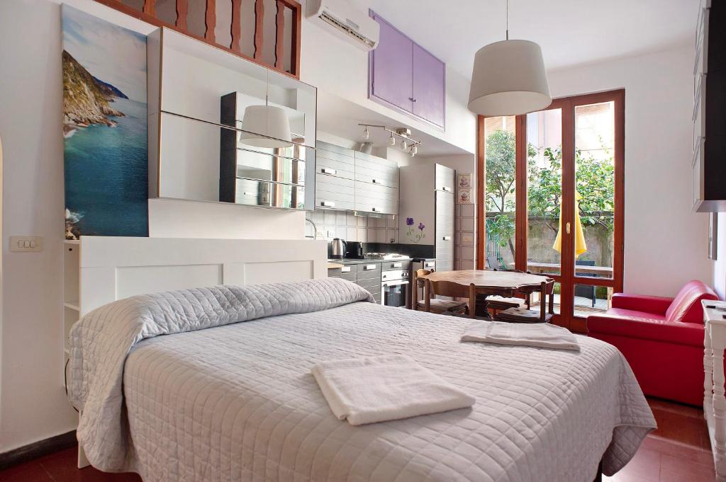 Il comprend une chambre blanche avec un lit et une cuisine. dans l'établissement Appartamento Rita, à Levanto