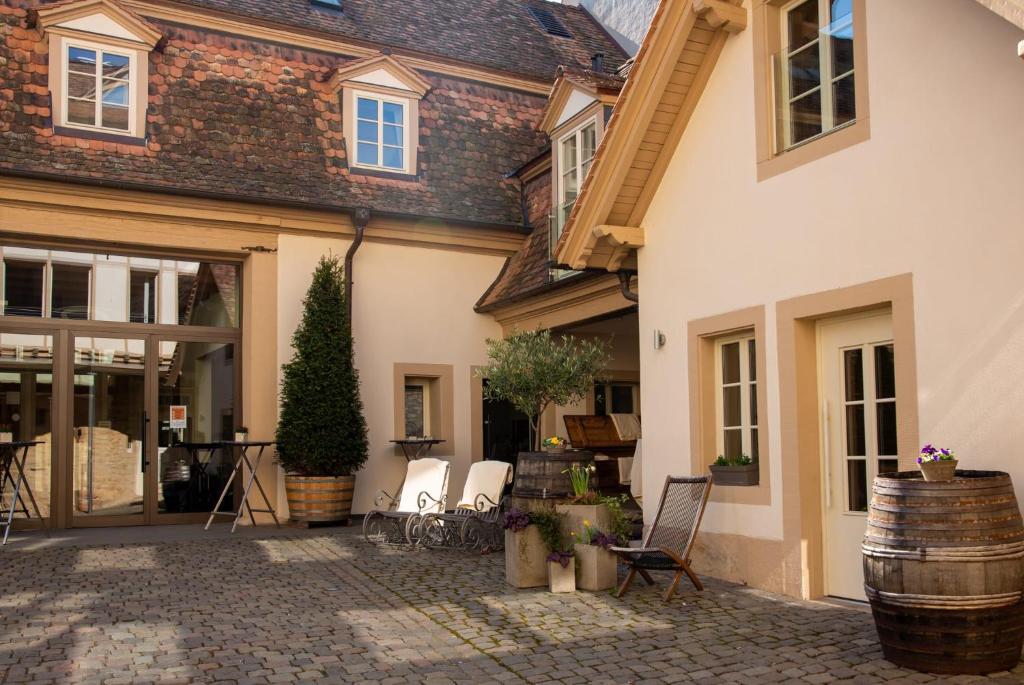 a courtyard of a house with chairs and a barrel at Altstadthof Freinsheim in Freinsheim