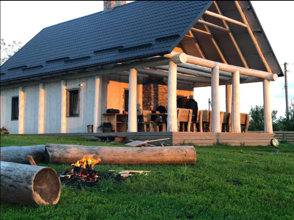 a house with a fire in the grass in front of it at Zubyria Lodge in Krekhayev
