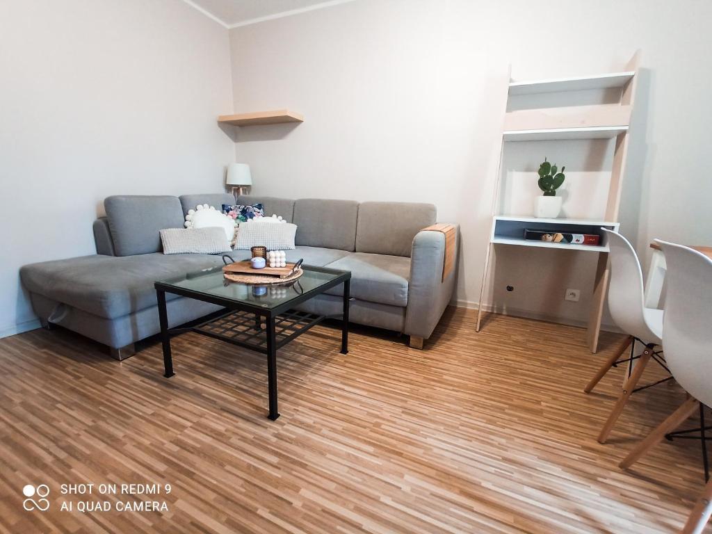uma sala de estar com um sofá e uma mesa em Apartament boBoski em Wadowice