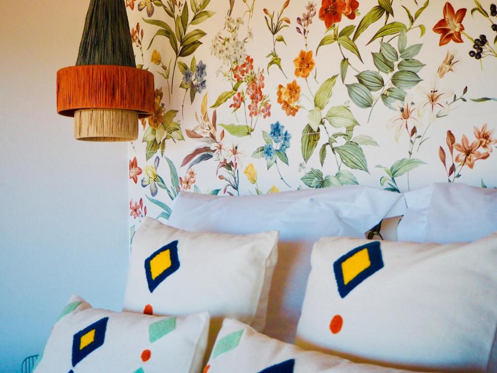 - une chambre dotée d'un lit avec des oreillers et d'un papier peint à fleurs dans l'établissement El PENTHOUSE de La Casa Rebonita, à Candelario