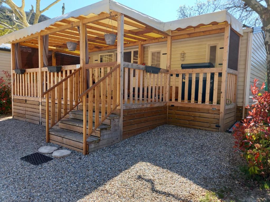 Cabaña de madera grande con una escalera que conduce a ella en Mobil-home camping, 