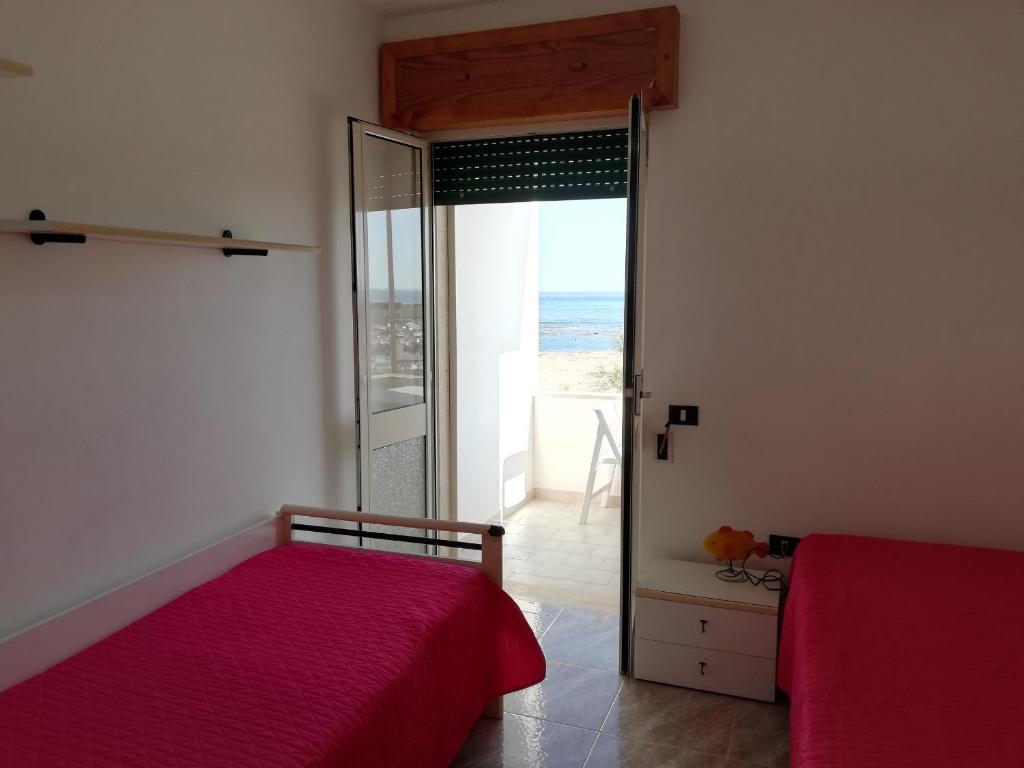 Postel nebo postele na pokoji v ubytování 054 e 055 Spiaggia direttamente sulla spiaggia di SalentoInVacanza.Com
