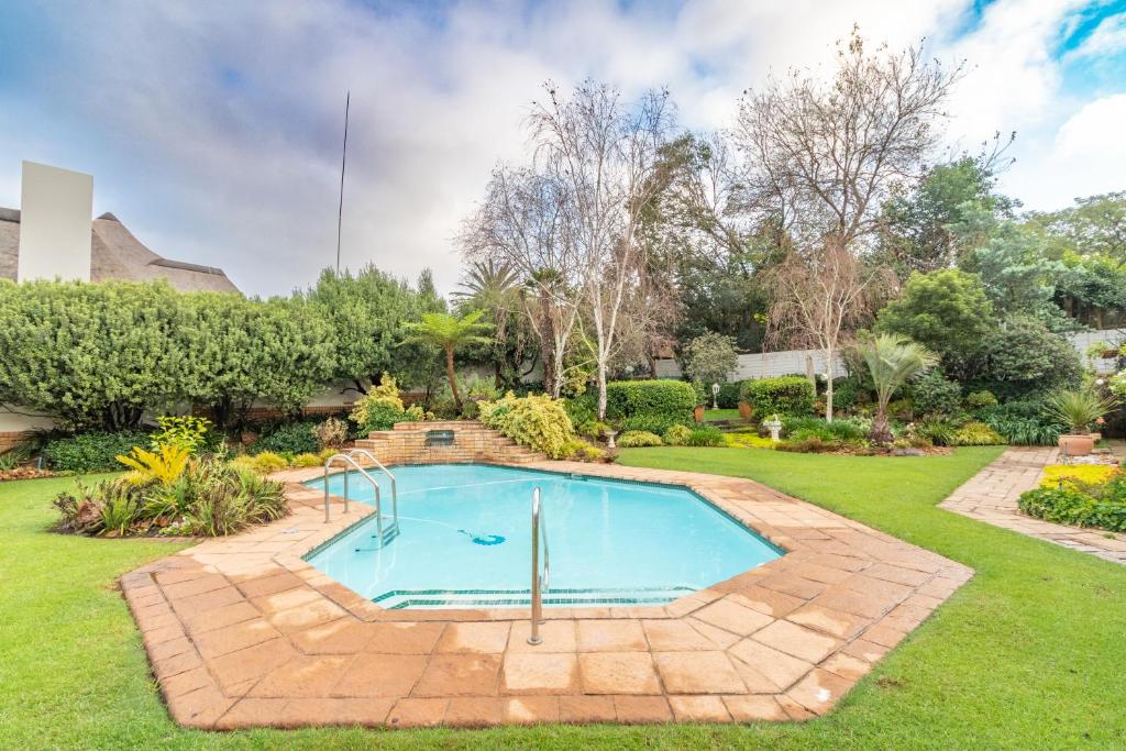 a swimming pool in a yard with a lawn at RSA Lodge in Benoni