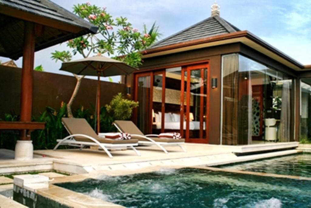 a villa with a swimming pool and a house at Villa Ava Seminyak Bali in Seminyak