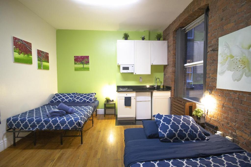 sala de estar con 2 camas y cocina en NYC Empire Apartments en Nueva York