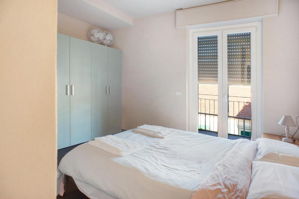 um quarto branco com uma cama e uma janela em Casa Maria Eugenia em Levanto