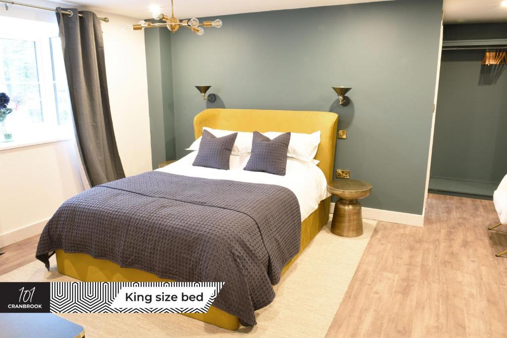 a bedroom with a king size bed with blue walls at Newly Refurbished Luxury Hotel Style Accommodation in Milton Keynes