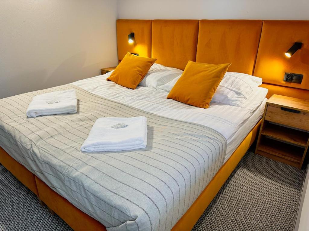 1 dormitorio con 1 cama grande y 2 toallas. en Apartamenty Czerwone Korale, en Cielimowo