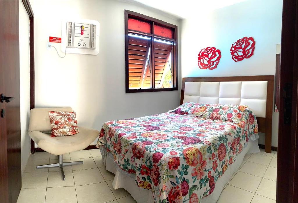 a bedroom with a bed and a chair and a window at Casa em condomínio, beira mar e piscina Barra de São Miguel - Maceió- AL in Barra de São Miguel