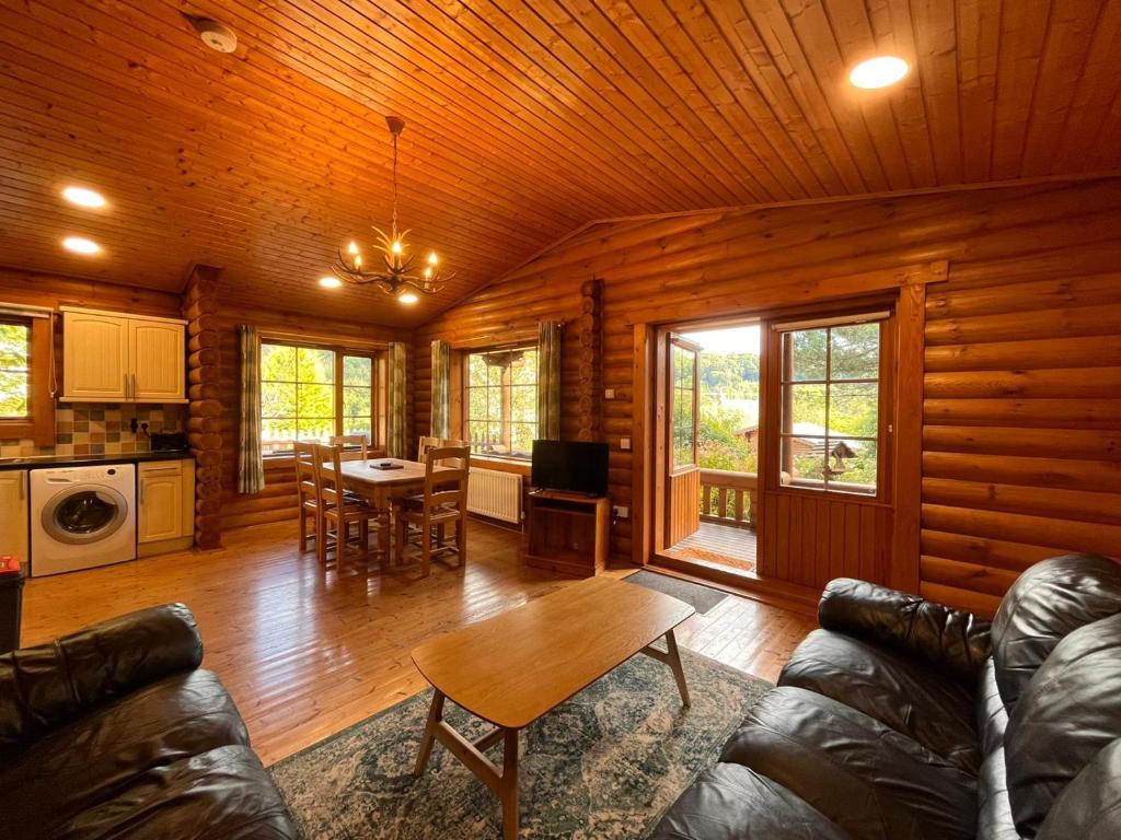 a living room with a couch and a table at Countryside 3 Bedroom Log Cabin With Private Hot Tub - Ash in Leominster