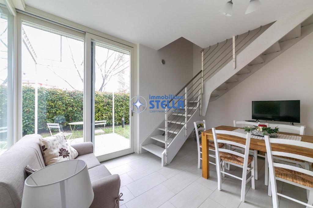 sala de estar con sofá, mesa y TV en Villa Stella, en Lido di Jesolo