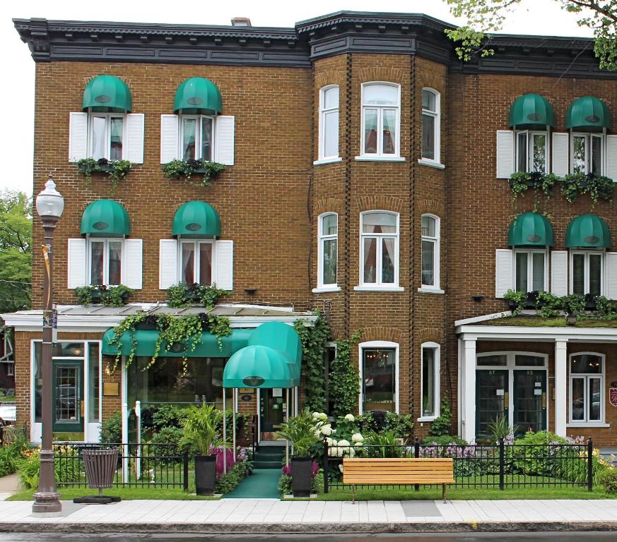 a large brick building with green awnings at Hotel Relais Charles-Alexandre in Quebec City