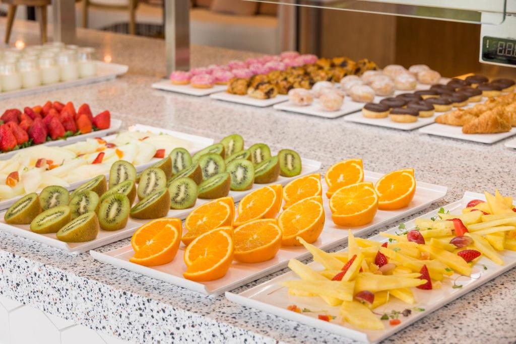 a buffet filled with different types of fruits and pastries at Ilunion Islantilla in Islantilla