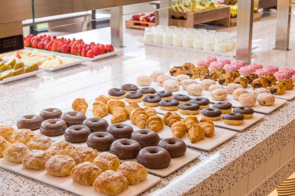 a display of donuts on trays in a bakery at Ilunion Islantilla in Islantilla