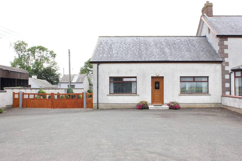 una casa blanca con valla y entrada en Carrick House, Mid-Ulster en Knockloughrim