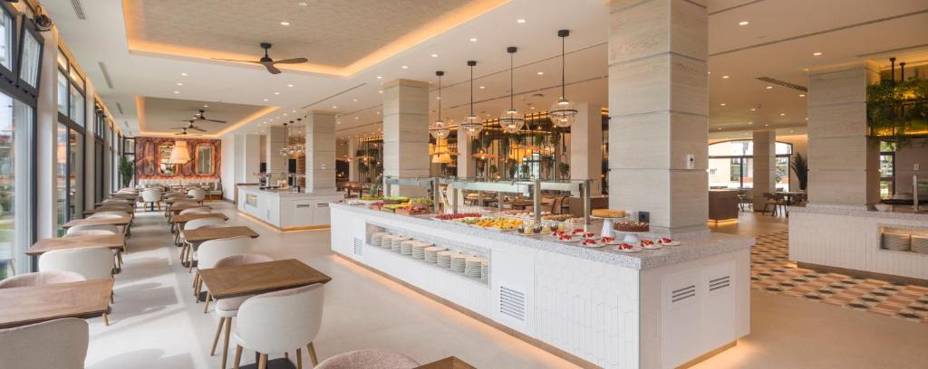 a restaurant with a bar and some tables and chairs at Ilunion Islantilla in Islantilla